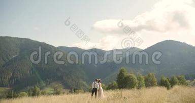 喀尔巴阡山脉的一对年轻可爱的夫妇。 在阳光明媚的日子里浪漫的约会或恋爱。 大气。 4K.